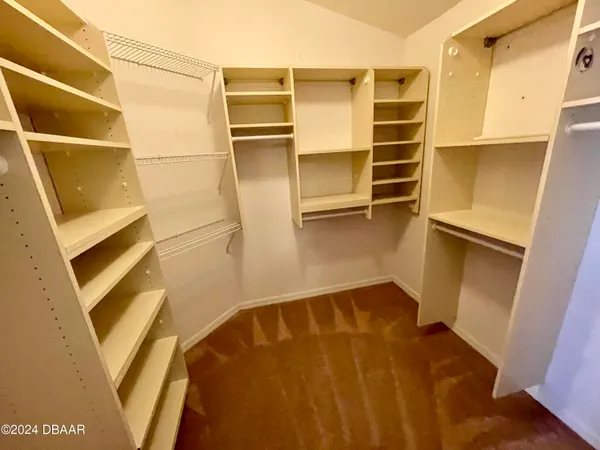 a view of walk in closet with empty racks
