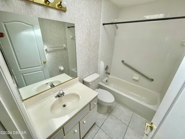 a bathroom with a sink toilet granite vanity and shower