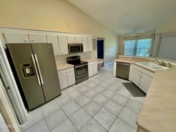 a kitchen with stainless steel appliances a refrigerator sink and microwave