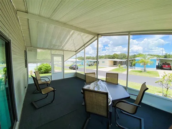 a dining room with furniture and a floor to ceiling window