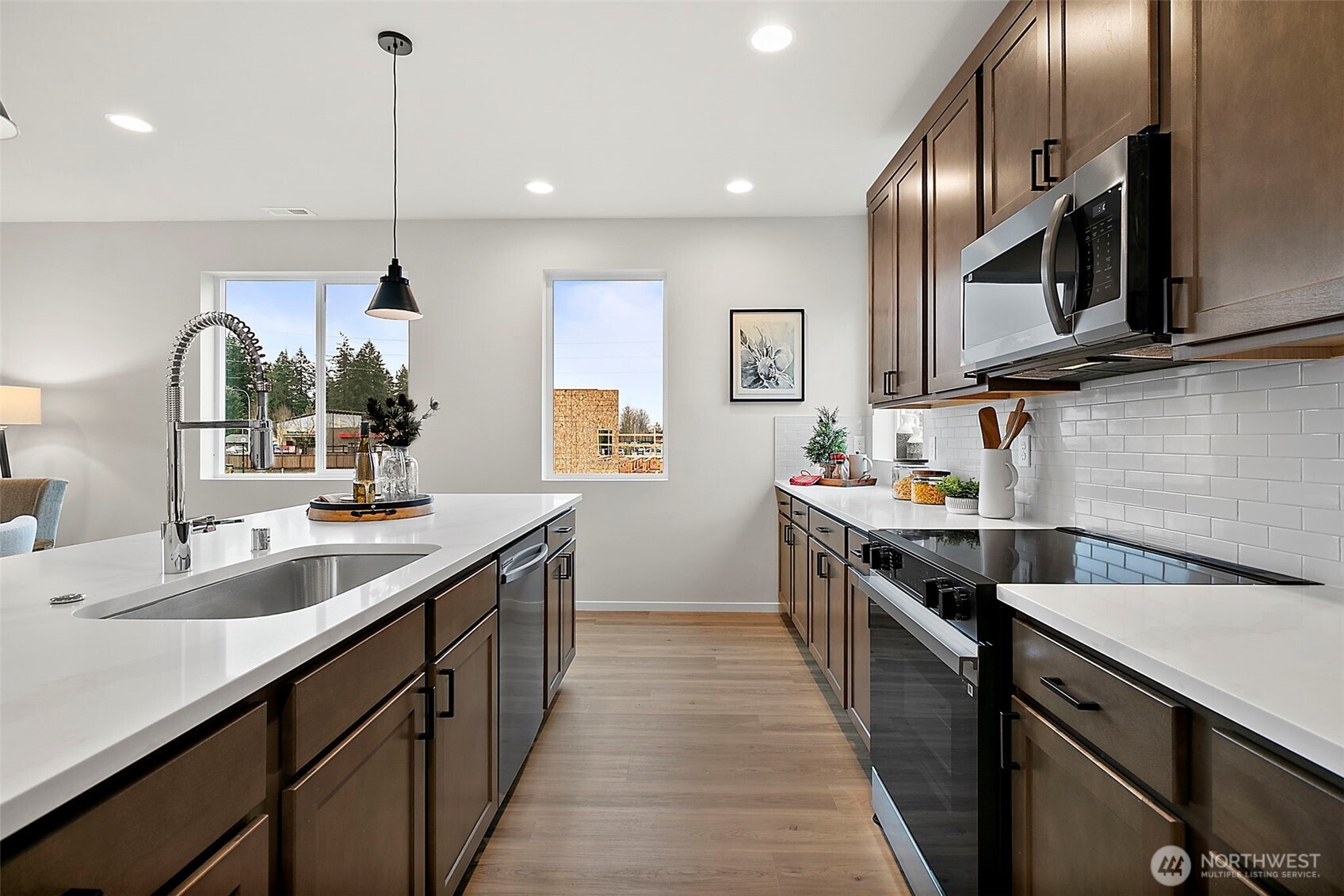 18510 Southeast 271st Place Covington, WA 98042 - Photo 8 of 23 a kitchen with stainless steel appliances granite countertop a sink a stove and a wooden floors