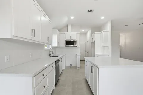 a kitchen with stainless steel appliances white cabinets and a sink