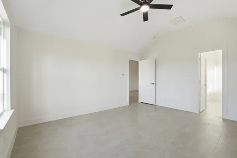 an empty room with a window and a ceiling fan