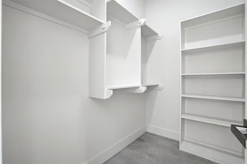 a view of walk in closet with empty racks