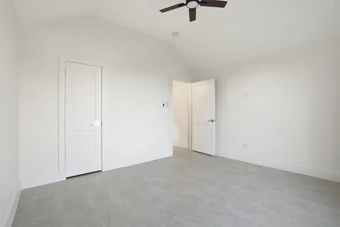 an empty room with a ceiling fan and window