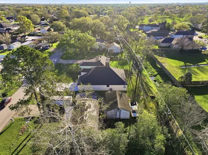 an aerial view of residential houses with outdoor space and trees