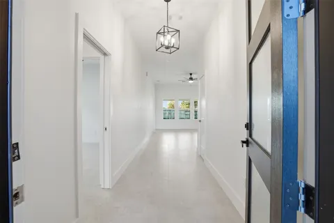 a view of hallway with stairs and wooden floor