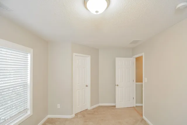 a view of a room with wooden floor and white walls