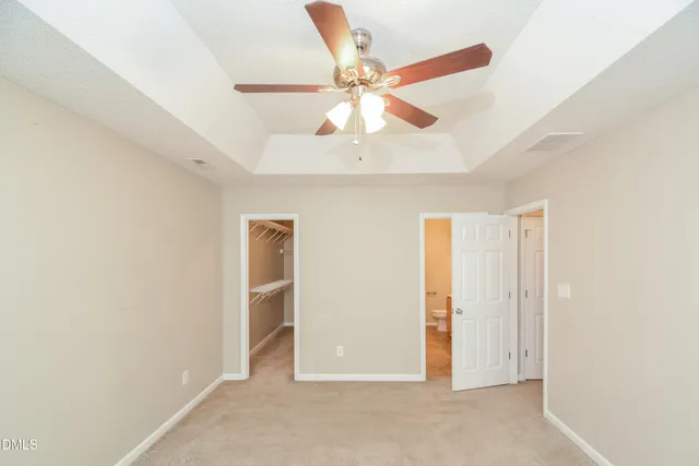 an empty room with closet and a ceiling fan