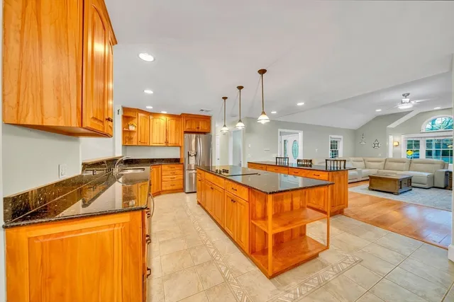 a large kitchen with stainless steel appliances granite countertop a large counter top a stove and a refrigerator