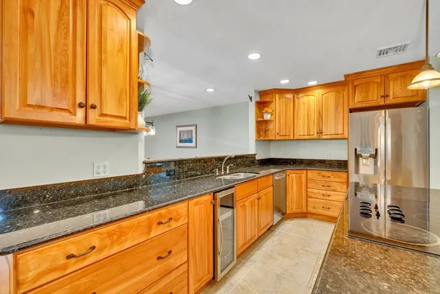 a large kitchen with stainless steel appliances granite countertop a sink and cabinets