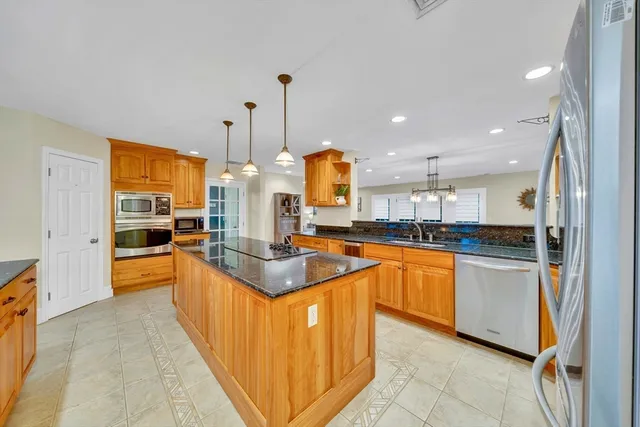 a kitchen with stainless steel appliances granite countertop a sink and a refrigerator