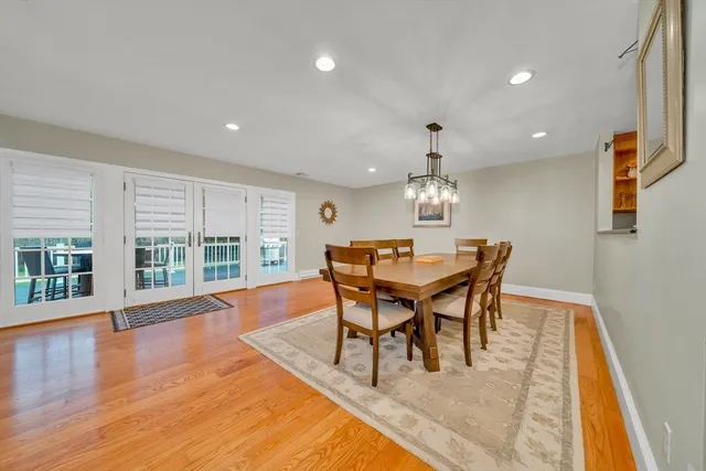 a dining room with wooden floor and window
