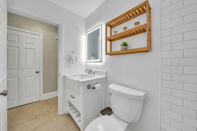 a bathroom with a toilet sink and mirror
