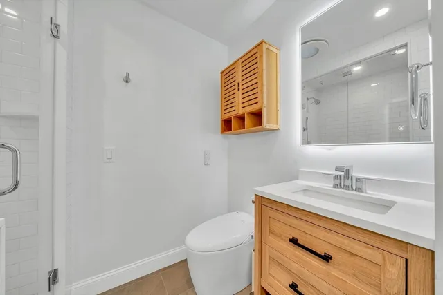 a bathroom with a sink a toilet and a mirror