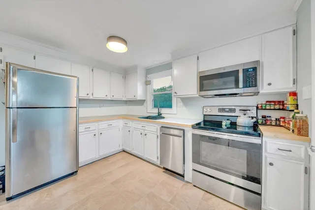 a kitchen with stainless steel appliances granite countertop a refrigerator sink stove microwave and cabinets