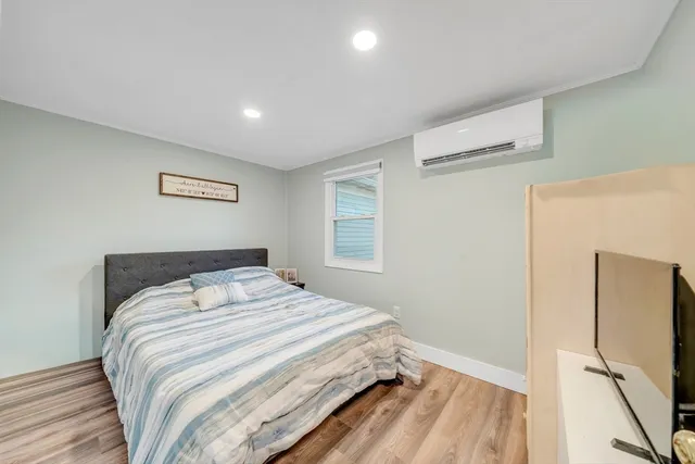 a bedroom with a bed and a refrigerator