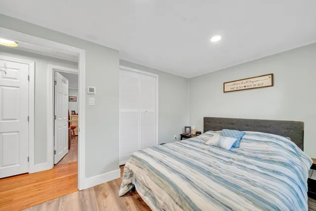 a bedroom with a bed and wooden floor