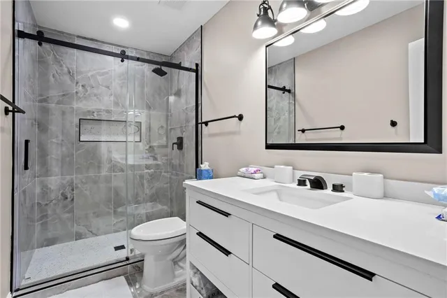 a bathroom with a sink a toilet and shower