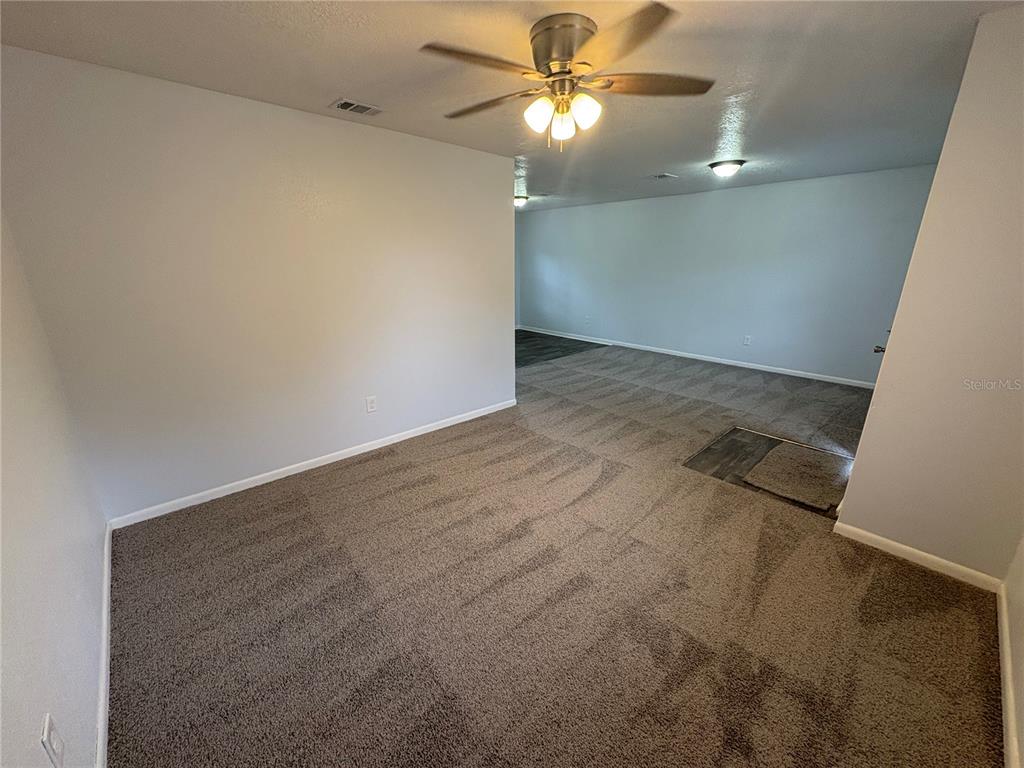 5206 Grimes Road Polk City, FL 33868 - Photo 3 of 17 an empty room with a chandelier fan and closet area