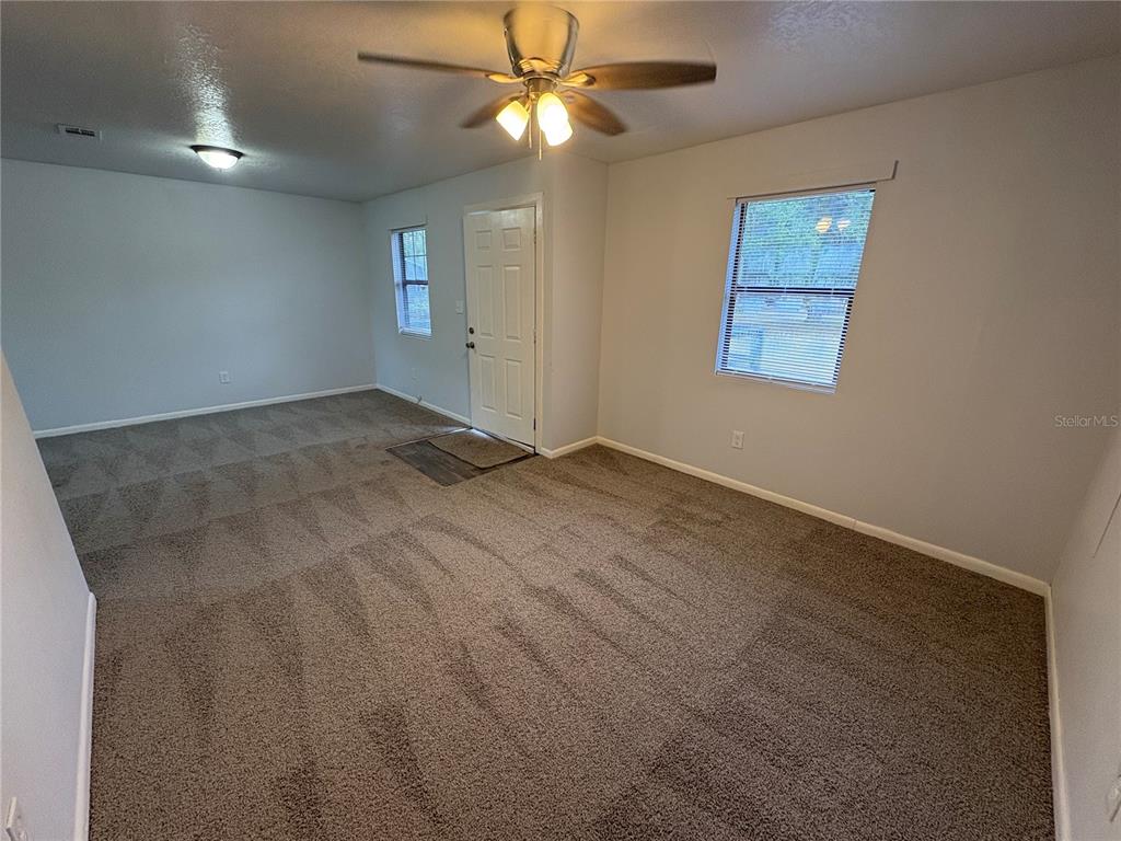 5206 Grimes Road Polk City, FL 33868 - Photo 4 of 17 an empty room with windows and fan