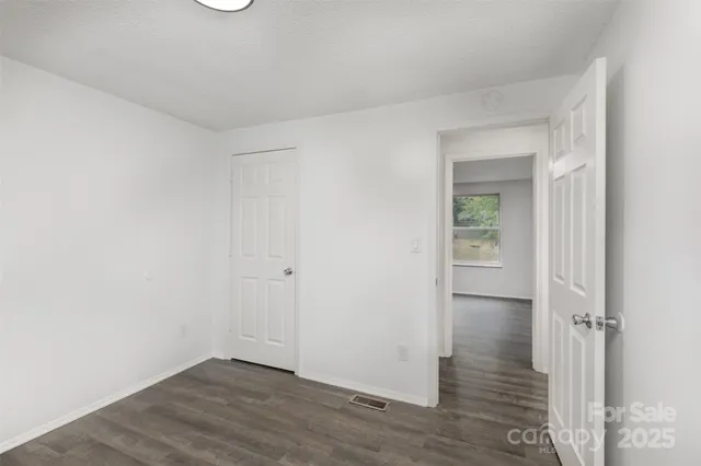 an empty room with wooden floor and closet