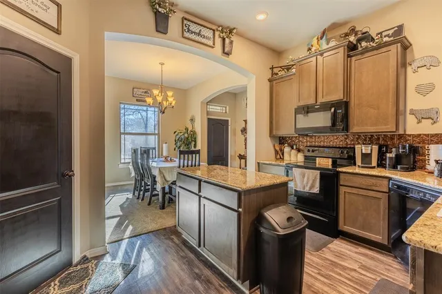 a kitchen with kitchen island a counter top space a sink stainless steel appliances and cabinets