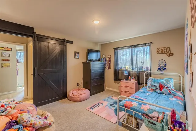a bedroom with baby bed toys and a window