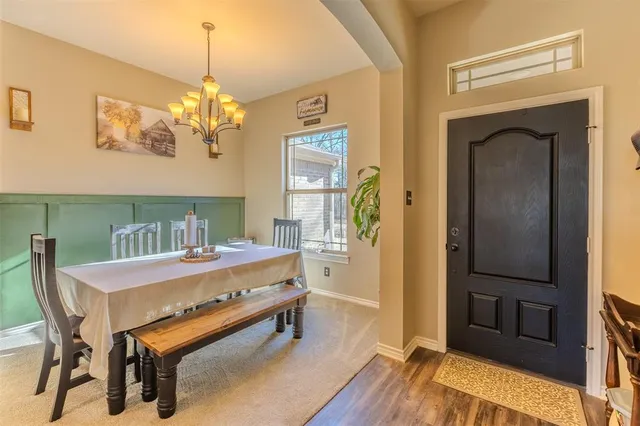 a dining room with furniture a chandelier and wooden floor