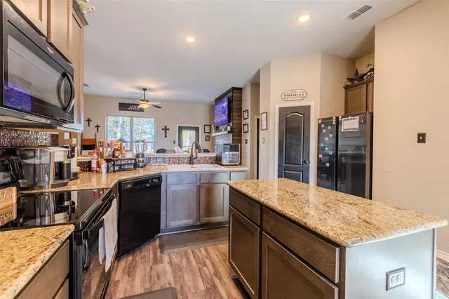 a kitchen with stainless steel appliances granite countertop a refrigerator a sink and a stove