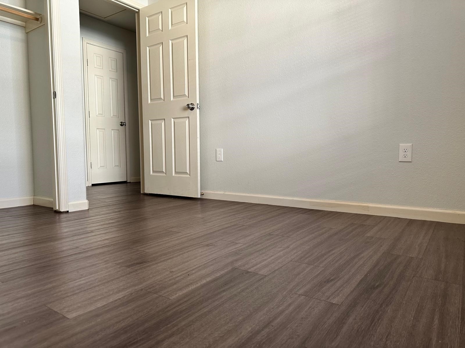 628 Luke Street, Unit A Dayton, TX 77535 - Photo 12 of 26 an empty room with wooden floor and windows