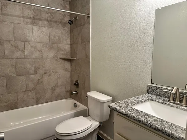 a bathroom with a granite countertop toilet sink and shower