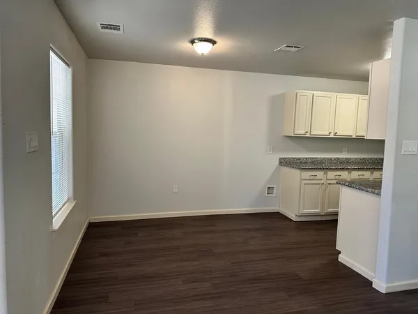 a view of kitchen with granite countertop cabinets and wooden floor