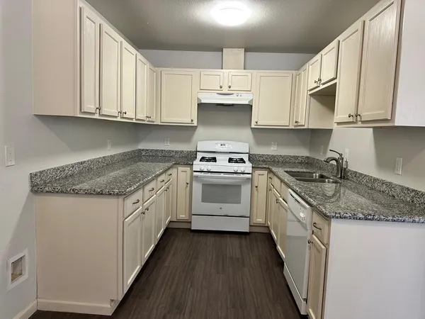 a kitchen with stainless steel appliances granite countertop a sink stove and cabinets