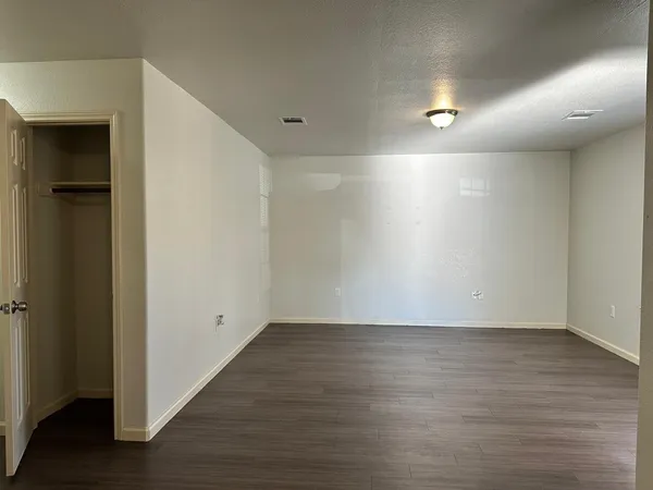 an empty room with wooden floor and closet