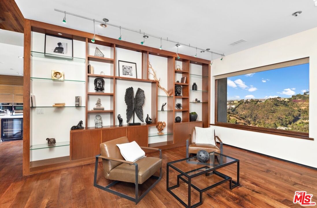 1018 Stradella Road Los Angeles, CA 90077 - Photo 16 of 22 a living room with furniture a flat screen tv and a floor to ceiling window