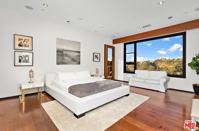 a spacious bedroom with a large bed and a large window