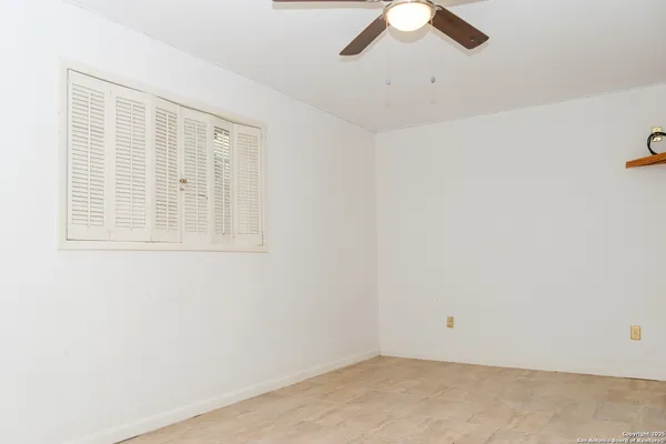 an empty room with chandelier fan