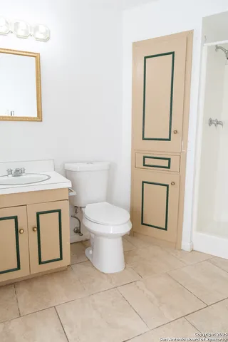 a bathroom with a toilet sink vanity and mirror