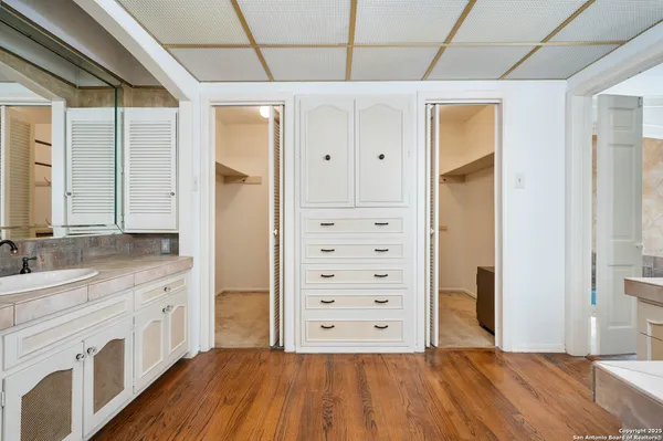 a spacious bathroom with a granite countertop sink mirror and a shower