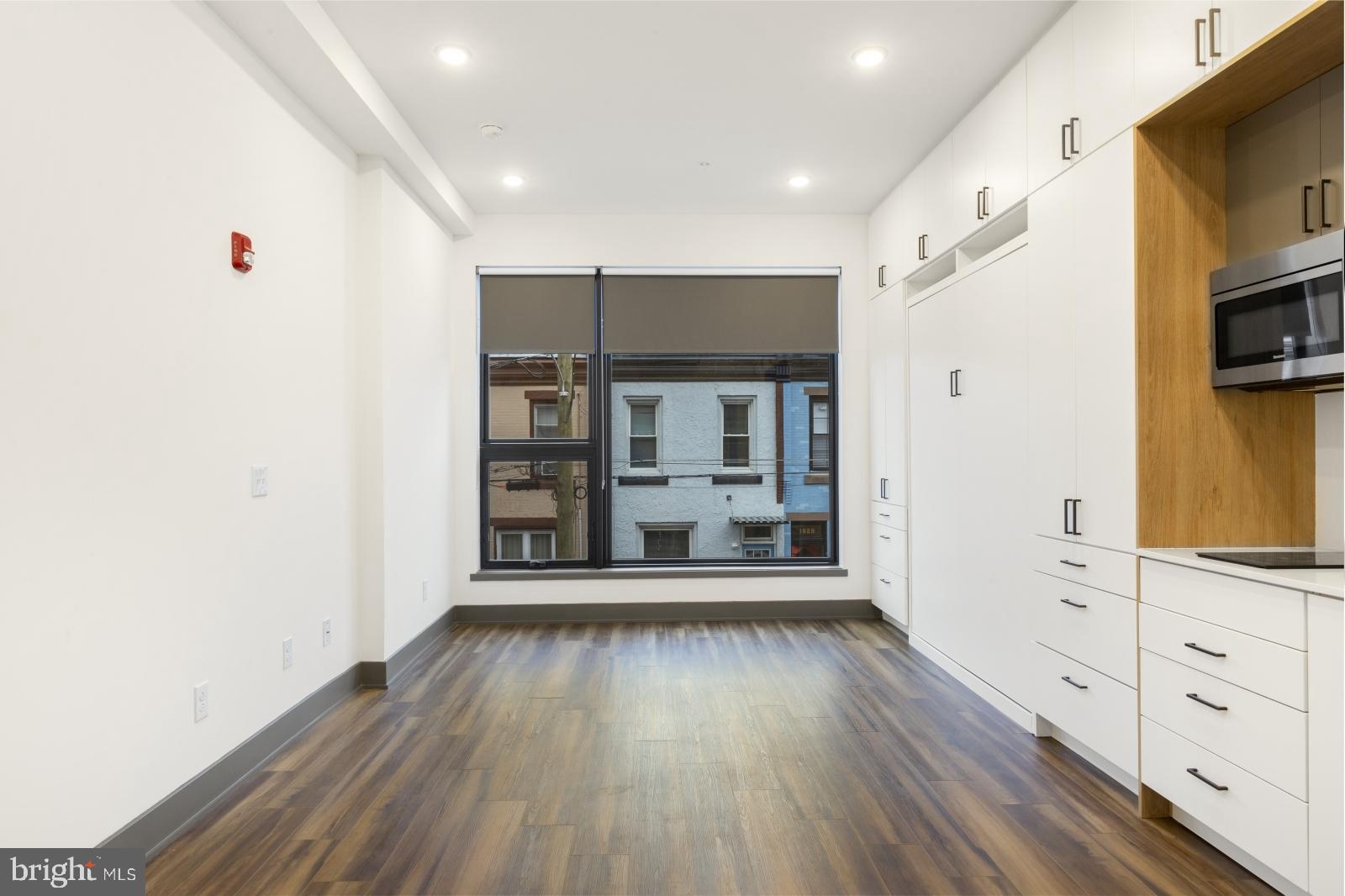 1935 East Hazzard Street, Unit 201 Philadelphia, PA 19125 - Photo 3 of 20 a view of an empty room with window and wooden floor