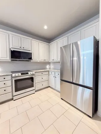 a kitchen with granite countertop a refrigerator sink and microwave