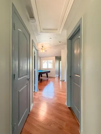a view of a hallway with wooden floor kitchen view and a refrigerator