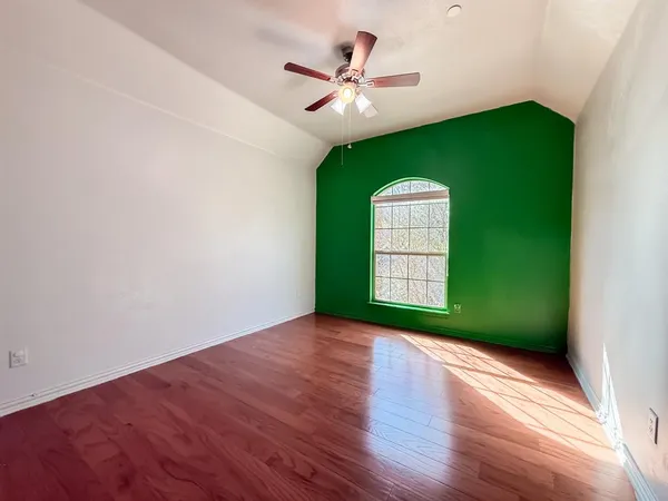 an empty room with a window and a fan