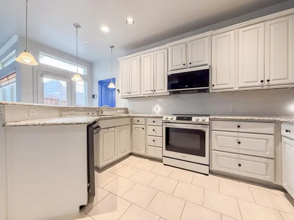 a kitchen with granite countertop white cabinets and white appliances