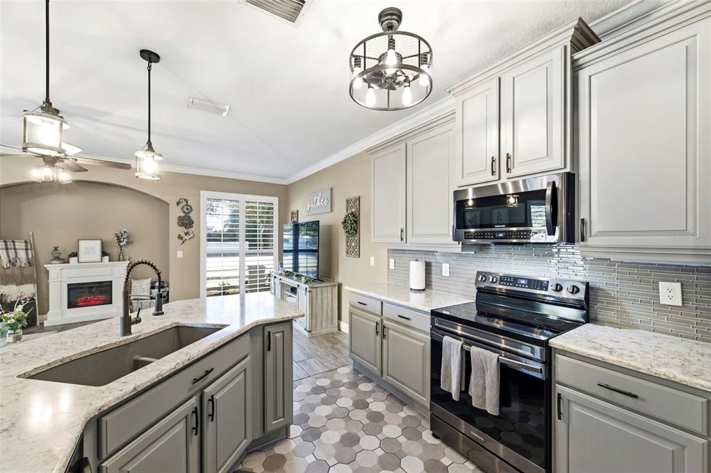 8408 Shallow Creek Court New Port Richey, FL 34653 - Photo 12 of 47 a kitchen with stainless steel appliances granite countertop a sink stove and microwave