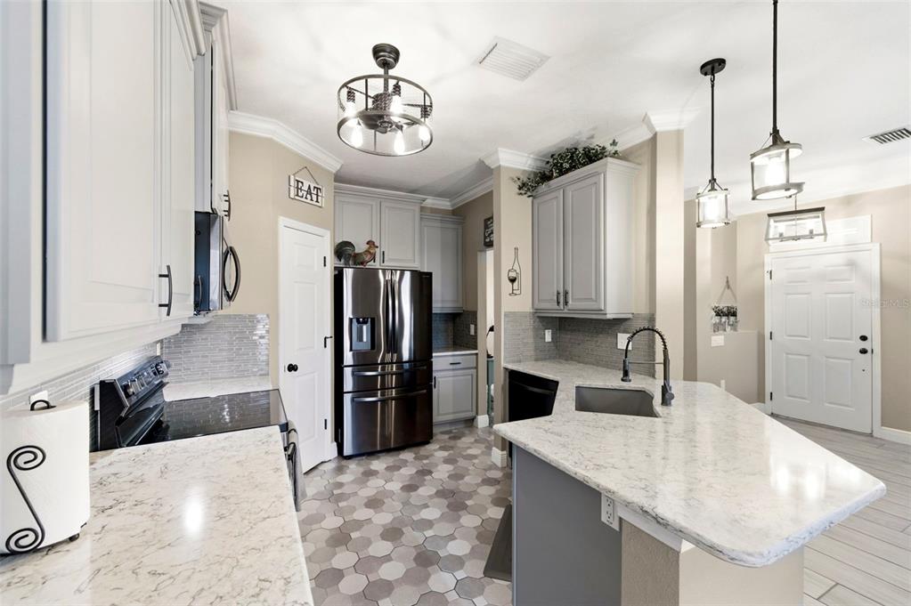 8408 Shallow Creek Court New Port Richey, FL 34653 - Photo 14 of 47 a kitchen with stainless steel appliances kitchen island granite countertop a sink and refrigerator