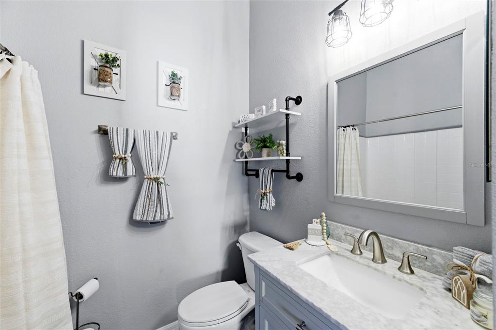 8408 Shallow Creek Court New Port Richey, FL 34653 - Photo 28 of 47 a bathroom with a granite countertop sink mirror vanity and toilet