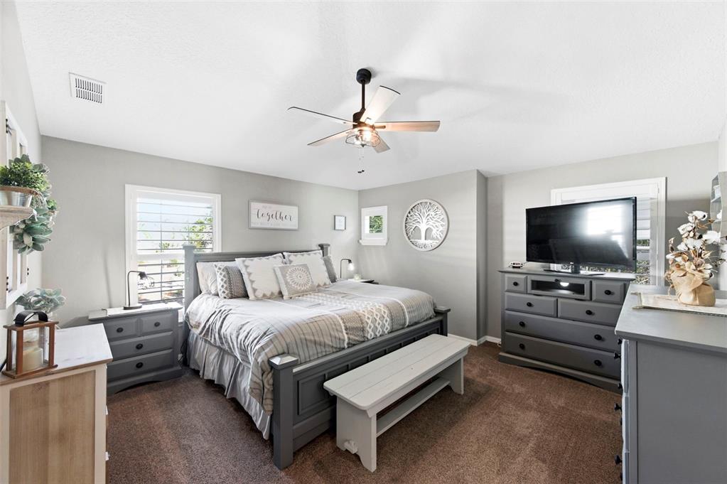 8408 Shallow Creek Court New Port Richey, FL 34653 - Photo 30 of 47 a spacious bedroom with a bed and a flat screen tv