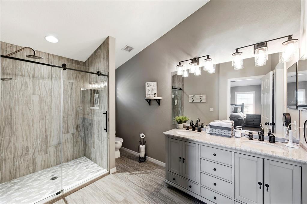 8408 Shallow Creek Court New Port Richey, FL 34653 - Photo 34 of 47 a bathroom with a double vanity sink mirror and shower
